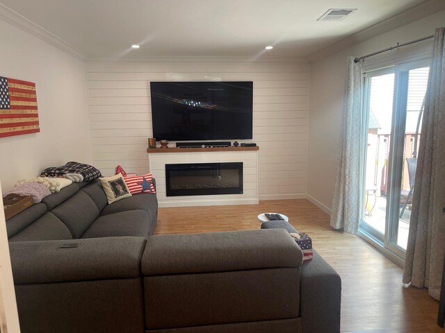 892 Skyline Dr Unit 892, Coram, NY 11727 - living area featuring wood finished floors, a glass covered fireplace, crown molding, recessed lighting, and wooden walls