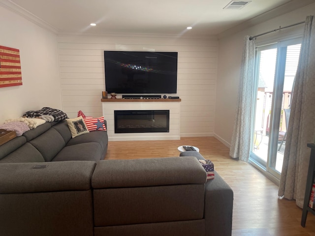 892 Skyline Dr Unit 892, Coram, NY 11727 - living room featuring wood finished floors, a glass covered fireplace, ornamental molding, and recessed lighting