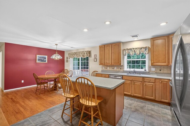 114 Bushwick Rd, Poughkeepsie, NY 12603 - kitchen with stainless steel appliances, light countertops, a breakfast bar, tasteful backsplash, and a kitchen island
