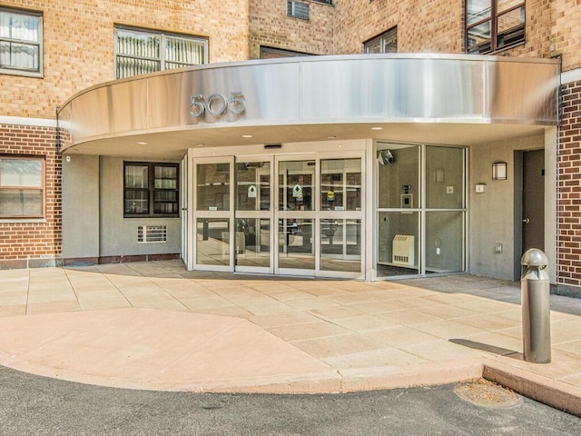 505 Central Ave Unit 618, White Plains, NY 10606 - view of exterior entry with brick siding, heating unit, and a patio area