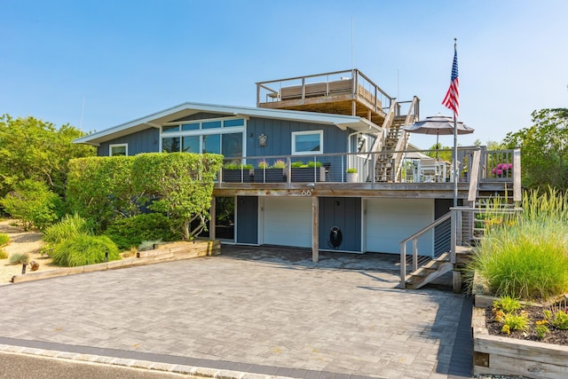 66 Hawser Dr, Oak Beach, NY 11702 - view of front of property featuring board and batten siding, stairway, an attached garage, decorative driveway, and a deck