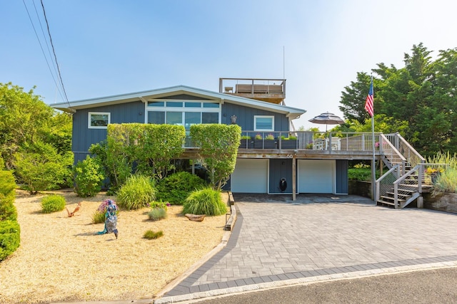 66 Hawser Dr, Oak Beach, NY 11702 - view of front facade featuring an attached garage, stairway, decorative driveway, and a deck