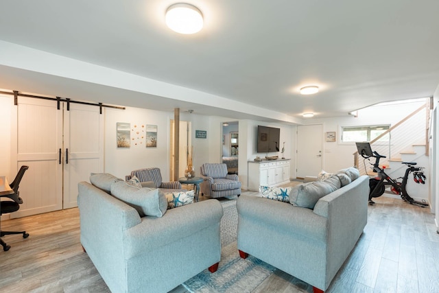 66 Hawser Dr, Oak Beach, NY 11702 - living area featuring light wood-style floors, stairway, and a barn door