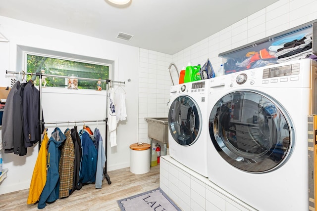 66 Hawser Dr, Oak Beach, NY 11702 - washroom with washer and clothes dryer and wood finished floors