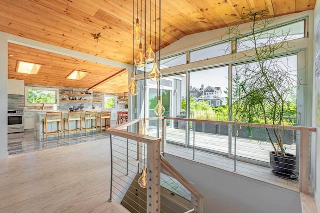 66 Hawser Dr, Oak Beach, NY 11702 - unfurnished dining area featuring lofted ceiling, wood ceiling, a skylight, and light wood-type flooring