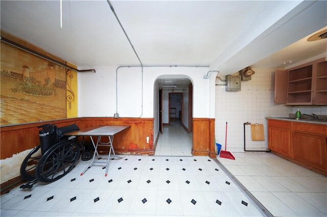4215 Bedford Ave, Brooklyn, NY 11229 - misc room with arched walkways, light tile patterned floors, electric panel, and a wainscoted wall