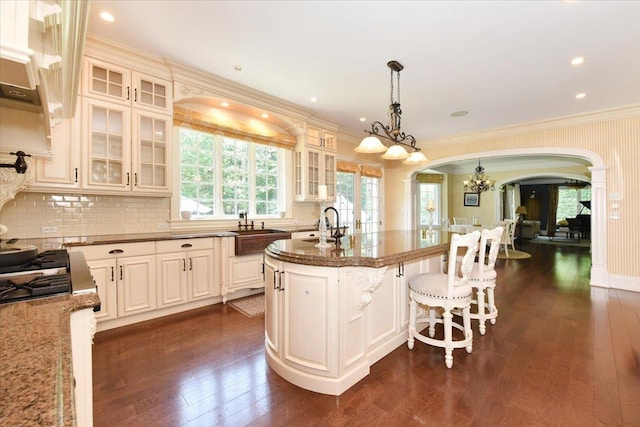 1616 Stewart Ln, Laurel Hollow, NY 11791 - kitchen featuring arched walkways, a chandelier, ornamental molding, dark wood-style floors, and dark stone counters