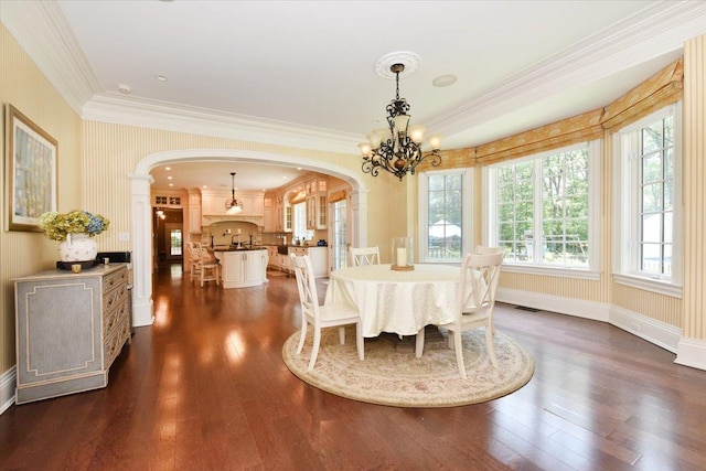 1616 Stewart Ln, Laurel Hollow, NY 11791 - dining area with arched walkways, a chandelier, dark wood-style flooring, and ornamental molding