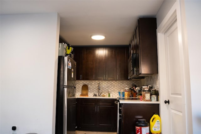 1602 Zerega Ave, Bronx, NY 10462 - kitchen featuring freestanding refrigerator, light countertops, dark brown cabinets, black microwave, and tasteful backsplash