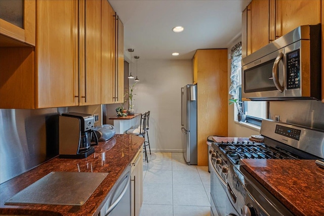 17-39 166th St Unit 3-68, Whitestone, NY 11357 - kitchen featuring stainless steel appliances, dark stone counters, recessed lighting, light tile patterned floors, and brown cabinetry