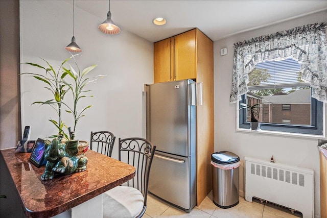 17-39 166th St Unit 3-68, Whitestone, NY 11357 - kitchen with radiator, freestanding refrigerator, light tile patterned floors, hanging light fixtures, and dark countertops