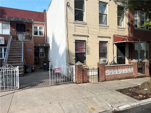 1363 64th St, Brooklyn, NY 11219 - view of front of house featuring brick siding, a gate, and a fenced front yard
