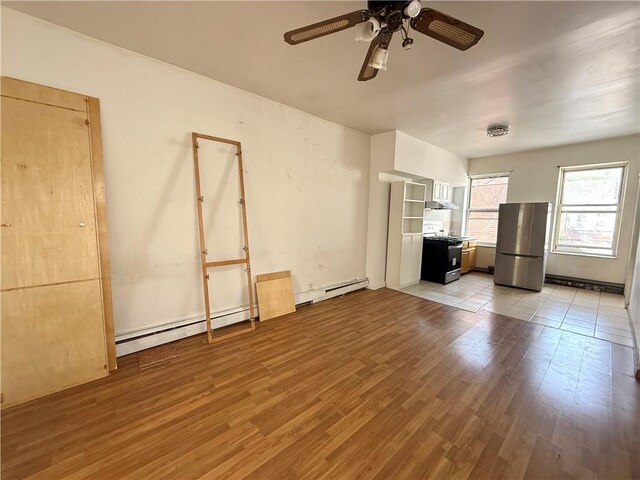 1363 64th St, Brooklyn, NY 11219 - unfurnished living room featuring light wood-type flooring, a ceiling fan, and a baseboard heating unit