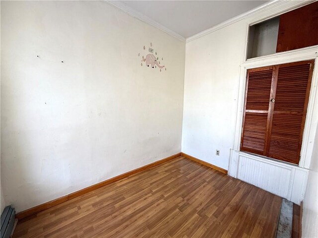 1363 64th St, Brooklyn, NY 11219 - empty room with wood finished floors, a baseboard radiator, and crown molding