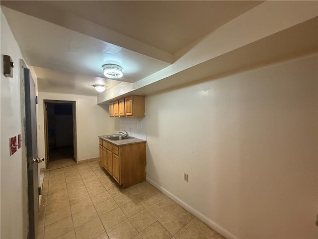 1363 64th St, Brooklyn, NY 11219 - kitchen featuring light tile patterned floors, light countertops, tasteful backsplash, and brown cabinets