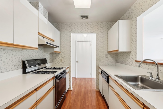 162 Deer Ct Dr, Middletown, NY 10940 - kitchen featuring range with gas cooktop, under cabinet range hood, dishwashing machine, light wood finished floors, and white cabinets
