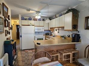 56 Pameeches Path, East Moriches, NY 11940 - kitchen featuring white appliances, a peninsula, ceiling fan, a breakfast bar, and white cabinetry
