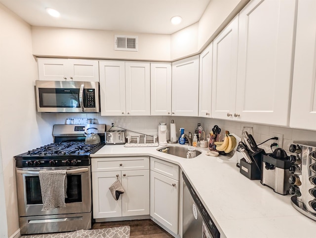 15 Fairview Cir, Middle Island, NY 11953 - kitchen featuring stainless steel appliances, light countertops, white cabinetry, tasteful backsplash, and wood finished floors