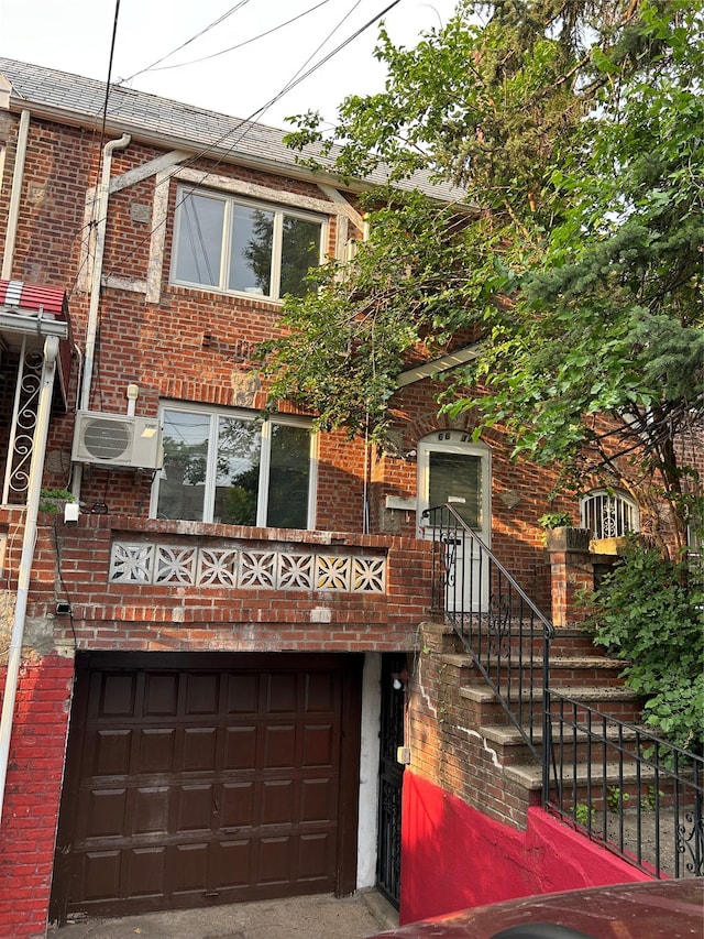66-37 Burns St, Rego Park, NY 11374 - view of front of house with brick siding, a garage, and an AC wall unit