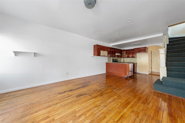 117-66 127th St, South Ozone Park, NY 11420 - unfurnished living room with stairs, hardwood / wood-style floors, and arched walkways