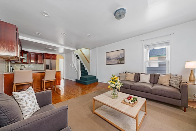 117-66 127th St, South Ozone Park, NY 11420 - living area featuring light wood-style floors, arched walkways, stairway, and recessed lighting