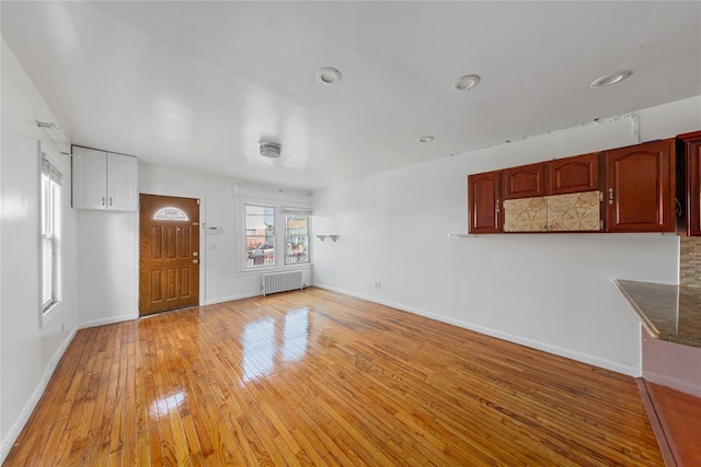 117-66 127th St, South Ozone Park, NY 11420 - unfurnished living room with radiator heating unit and light wood-style flooring