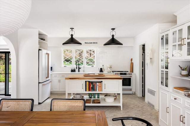 8 Maclean Dr, Pound Ridge, NY 10576 - kitchen featuring open shelves, stainless steel stove, freestanding refrigerator, radiator, and white cabinetry