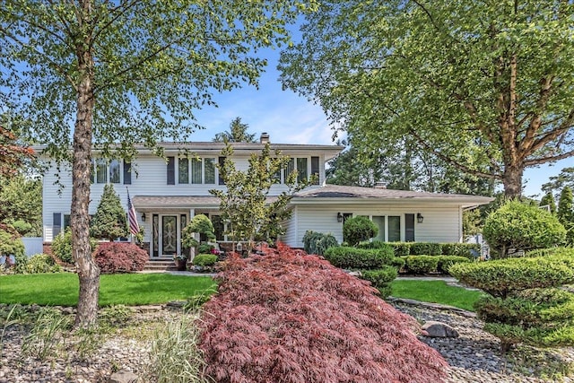 7 Woodstock Pl, Lake Grove, NY 11755 - traditional home featuring a chimney and a front yard