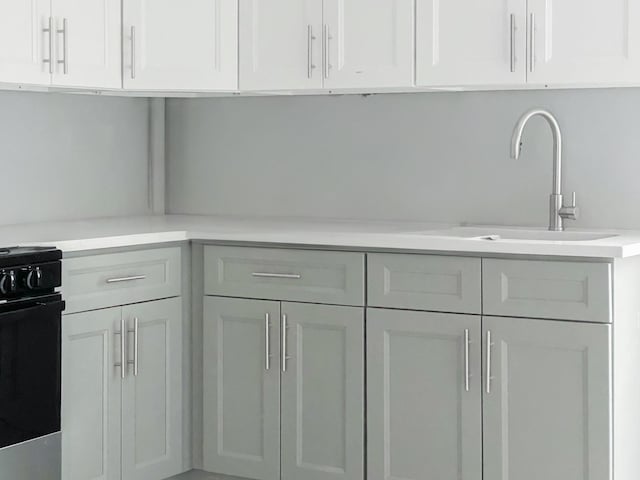 12 Liberty St, Newburgh, NY 12550 - kitchen with black range, light countertops, and white cabinets