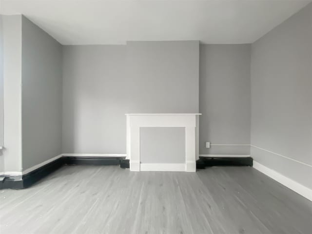 12 Liberty St, Newburgh, NY 12550 - empty room with wood finished floors and baseboards