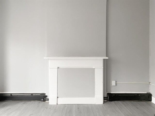 12 Liberty St, Newburgh, NY 12550 - detailed view of wood finished floors and a baseboard heating unit