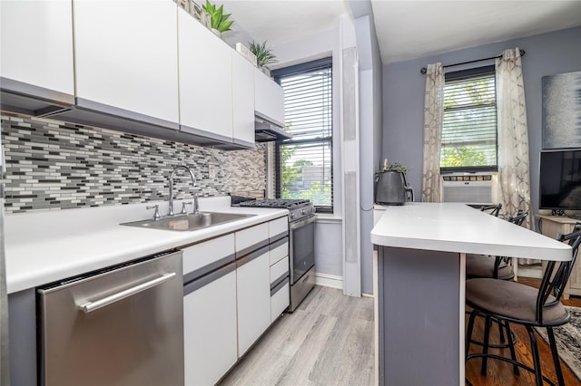12 Hempstead Ave Unit 1G, Rockville Centre, NY 11570 - kitchen with stainless steel appliances, a kitchen breakfast bar, white cabinets, and decorative backsplash