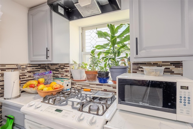 556 Long Beach Rd, Island Park, NY 11558 - kitchen featuring wall chimney range hood, decorative backsplash, and light countertops