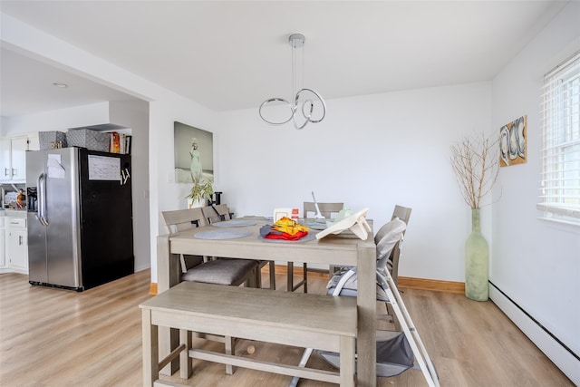 556 Long Beach Rd, Island Park, NY 11558 - dining space with a baseboard radiator, light wood-type flooring, and a chandelier