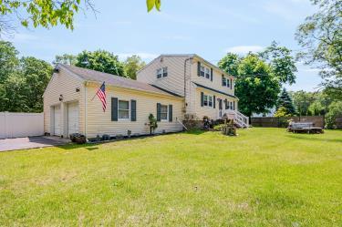 20 Wainwright St, Ronkonkoma, NY 11779 - back of house featuring a garage and driveway