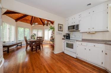 20 Wainwright St, Ronkonkoma, NY 11779 - kitchen featuring electric range, stainless steel microwave, dark wood-style flooring, and white cabinets