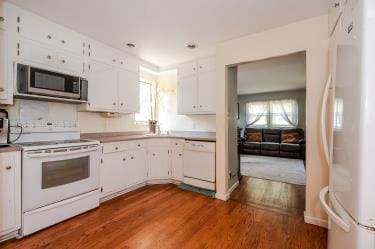 20 Wainwright St, Ronkonkoma, NY 11779 - kitchen with white appliances, white cabinets, dark wood finished floors, and light countertops