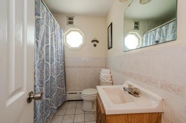 20 Wainwright St, Ronkonkoma, NY 11779 - full bath featuring baseboard heating, plenty of natural light, vanity, tile patterned flooring, and tile walls