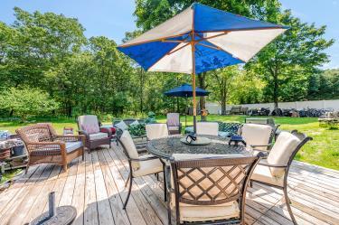 20 Wainwright St, Ronkonkoma, NY 11779 - wooden terrace with outdoor dining space, an outdoor living space, and view of scattered trees