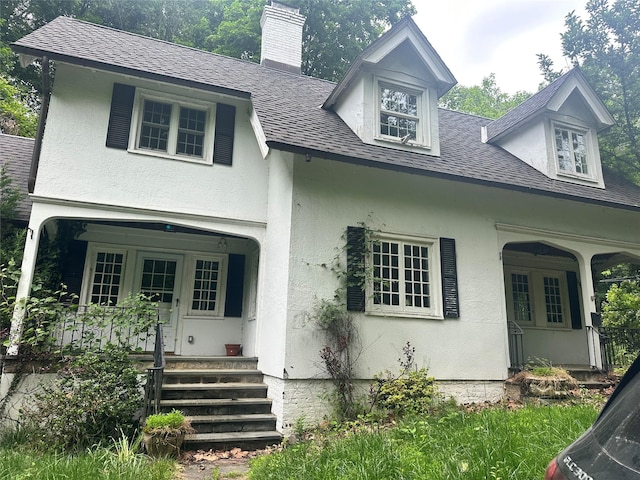 40 Broadway Unit 27, Irvington, NY 10533 - view of front of home with covered porch, a chimney, a shingled roof, and stucco siding