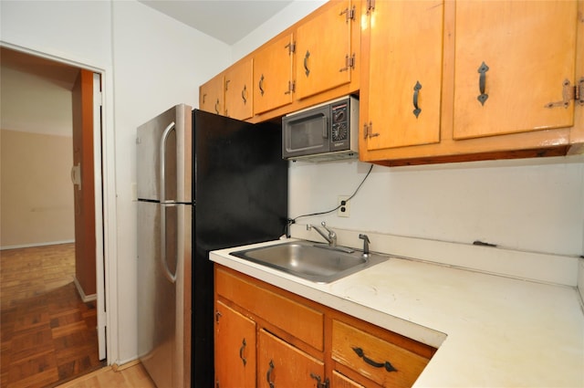 281 Garth Rd Unit B5D, Scarsdale, NY 10583 - kitchen featuring black microwave, freestanding refrigerator, light countertops, and brown cabinetry