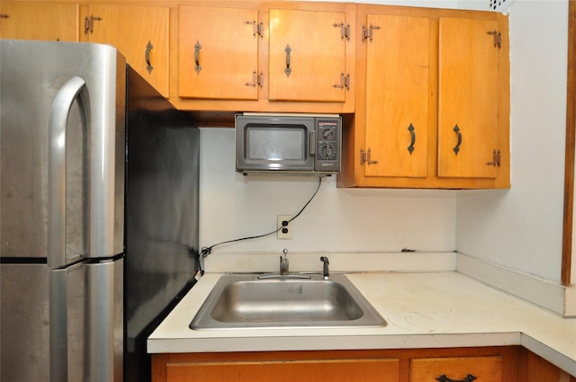 281 Garth Rd Unit B5D, Scarsdale, NY 10583 - kitchen featuring freestanding refrigerator, black microwave, light countertops, and brown cabinetry