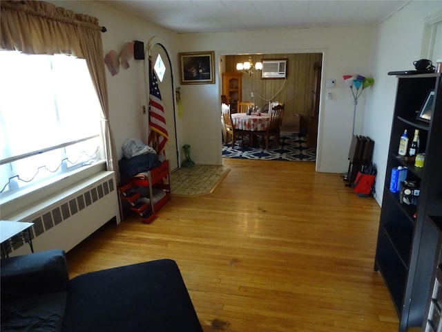 524 Polaris St, North Babylon, NY 11703 - living area featuring radiator heating unit, a chandelier, light wood-type flooring, and a wall mounted AC