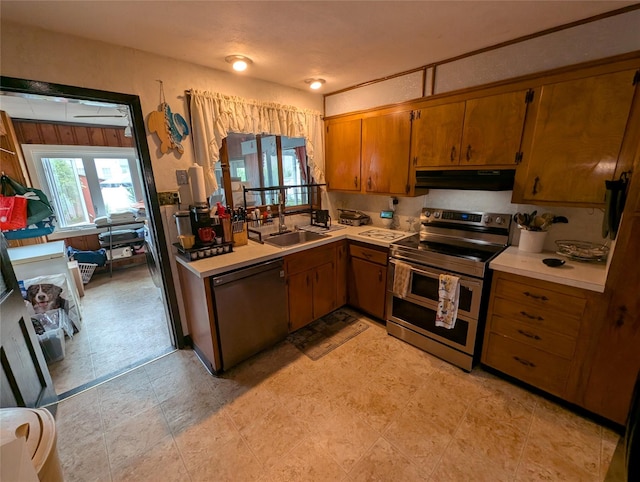 524 Polaris St, North Babylon, NY 11703 - kitchen with double oven range, dishwasher, under cabinet range hood, brown cabinets, and healthy amount of natural light