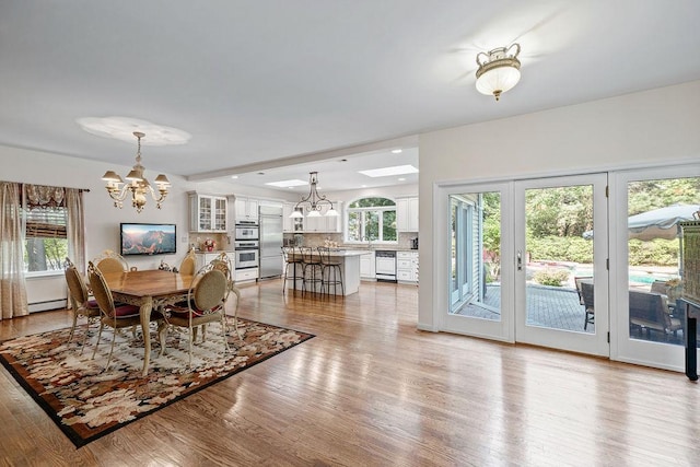17 Dunmore Rd, New City, NY 10956 - dining area featuring a chandelier, light wood-style floors, and baseboard heating