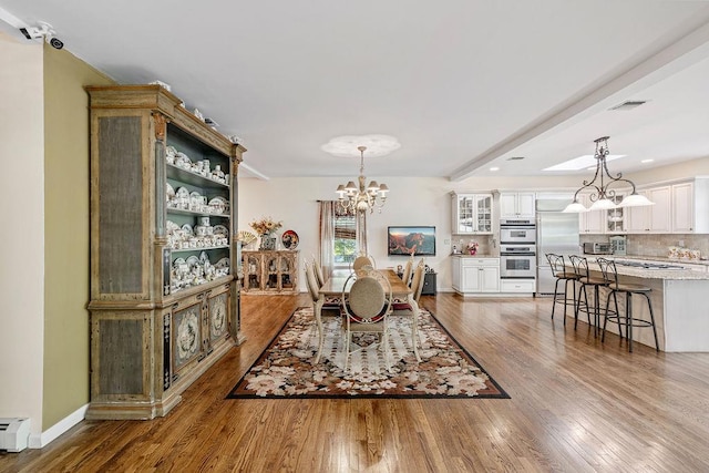 17 Dunmore Rd, New City, NY 10956 - dining space featuring a chandelier, wood finished floors, and a baseboard radiator