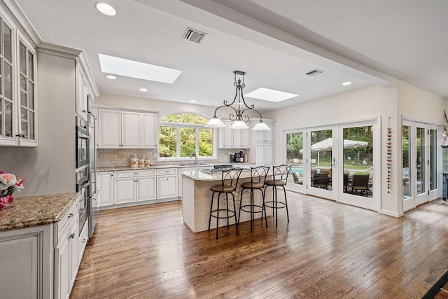 17 Dunmore Rd, New City, NY 10956 - kitchen featuring a skylight, a kitchen bar, light wood-style flooring, tasteful backsplash, and recessed lighting
