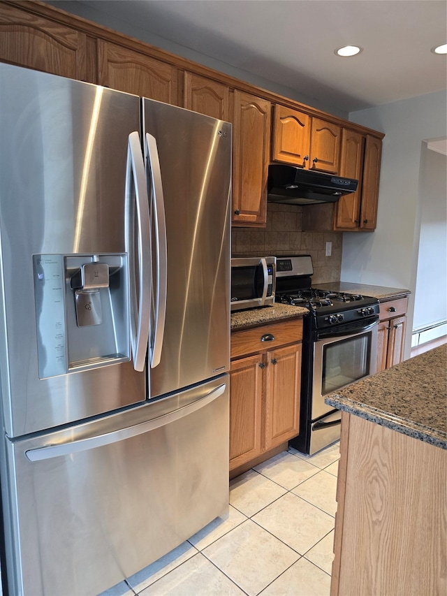 36 Hampton Ct, Middletown, NY 10941 - kitchen with stainless steel appliances, under cabinet range hood, dark stone countertops, backsplash, and light tile patterned flooring