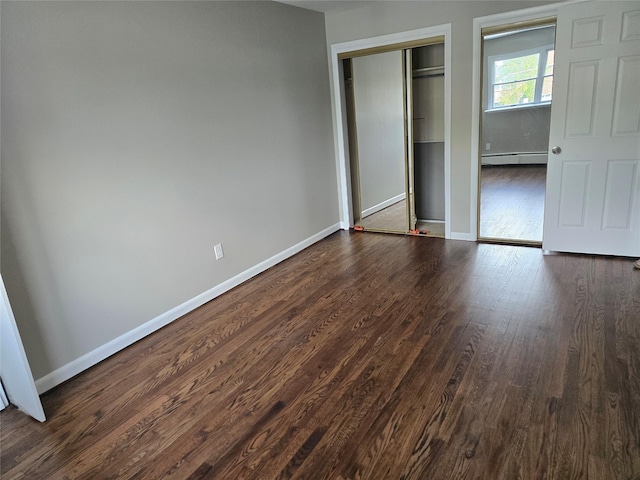 36 Hampton Ct, Middletown, NY 10941 - unfurnished bedroom with a baseboard heating unit, dark wood-style floors, and a closet