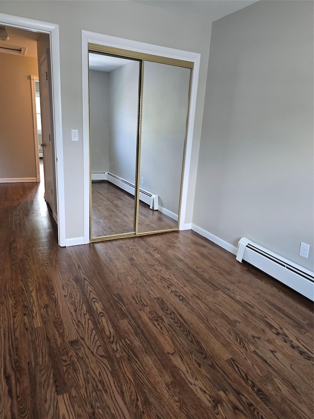 36 Hampton Ct, Middletown, NY 10941 - unfurnished bedroom featuring a baseboard heating unit, dark wood finished floors, and a closet